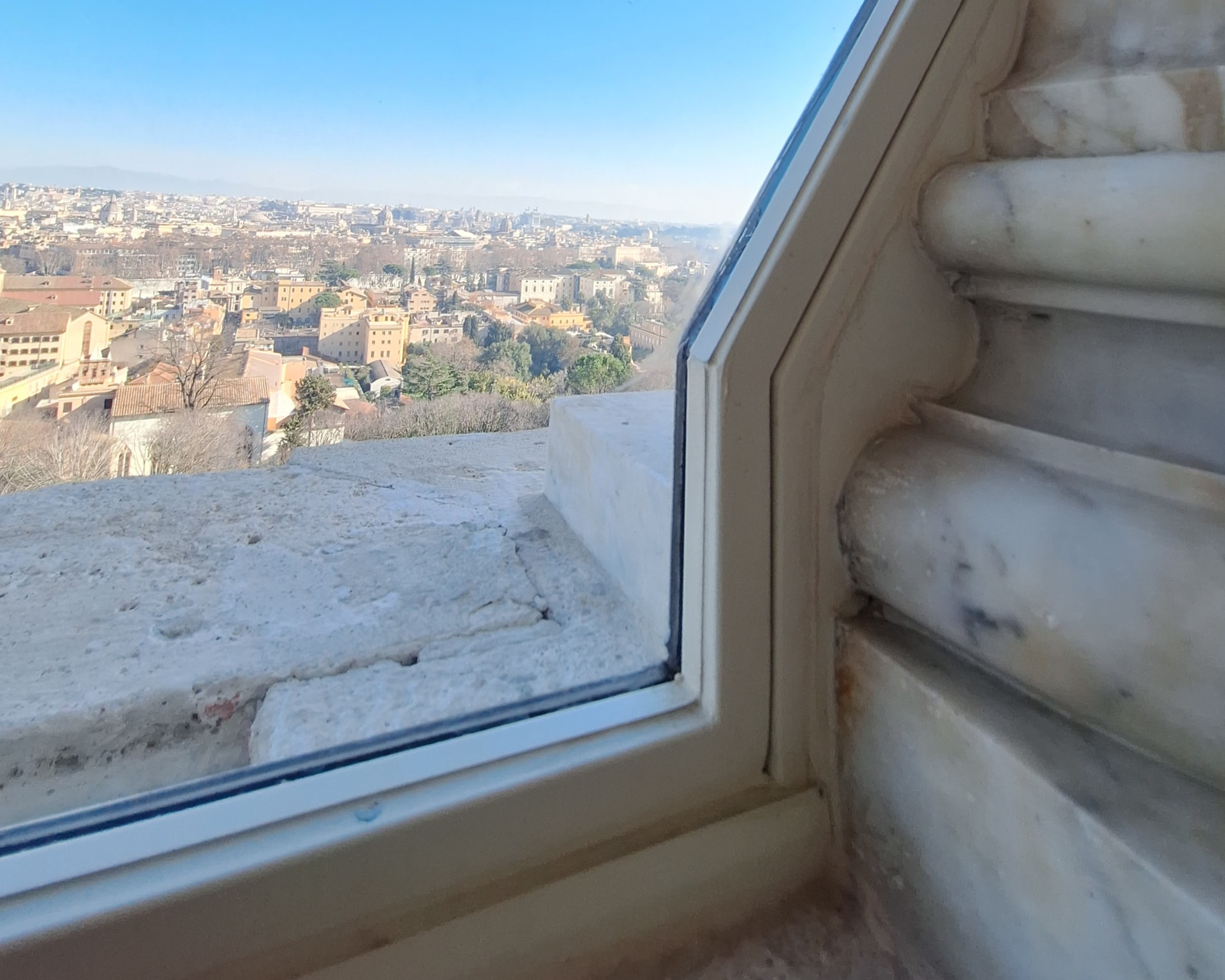 Vista di Roma attraverso il serramento sagomato della loggia