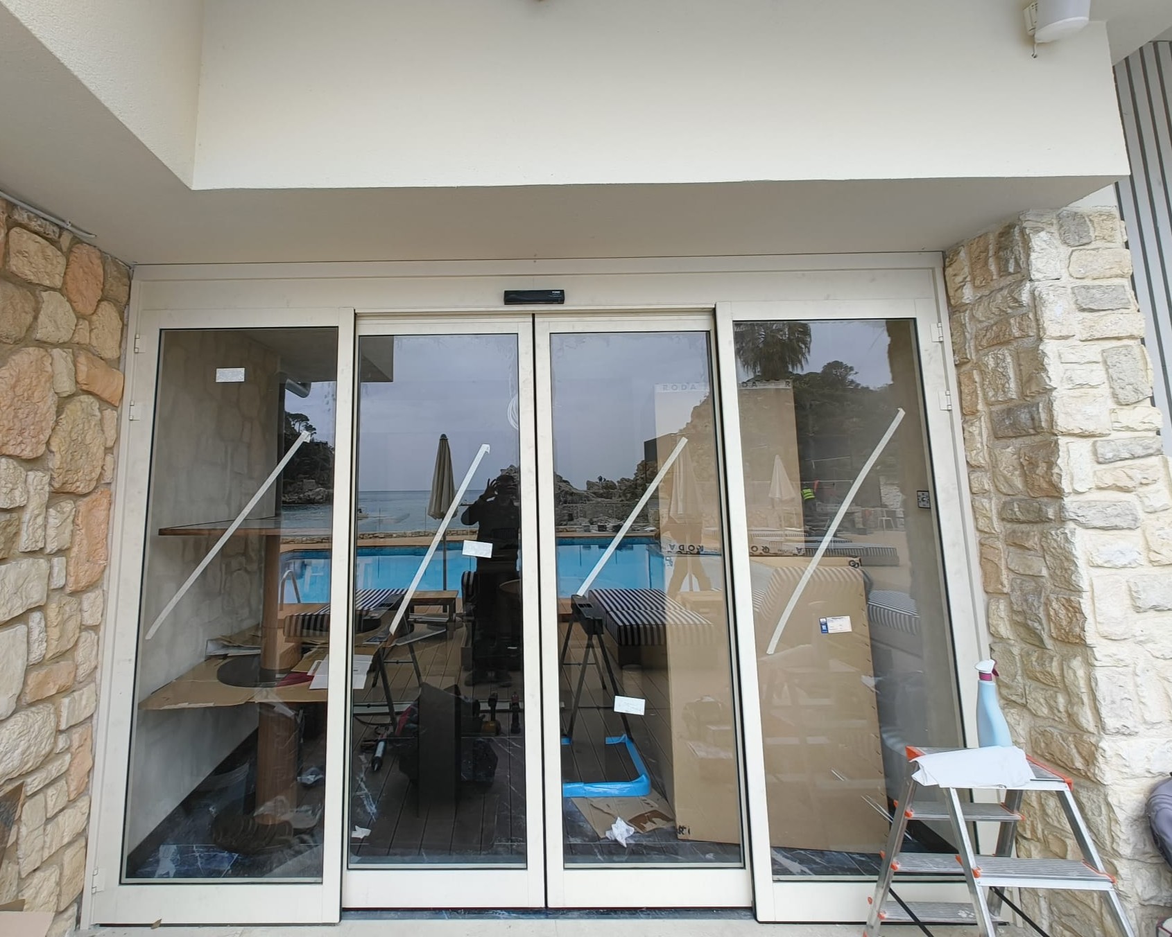 La vetrata del bar affacciata sulla piscina durante le finiture