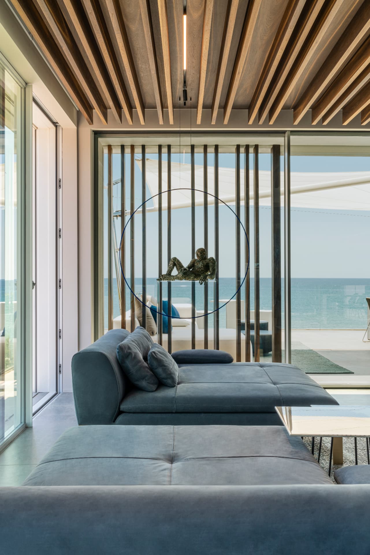 Zona living con vetrata sul mare e soffitto a lamelle in legno