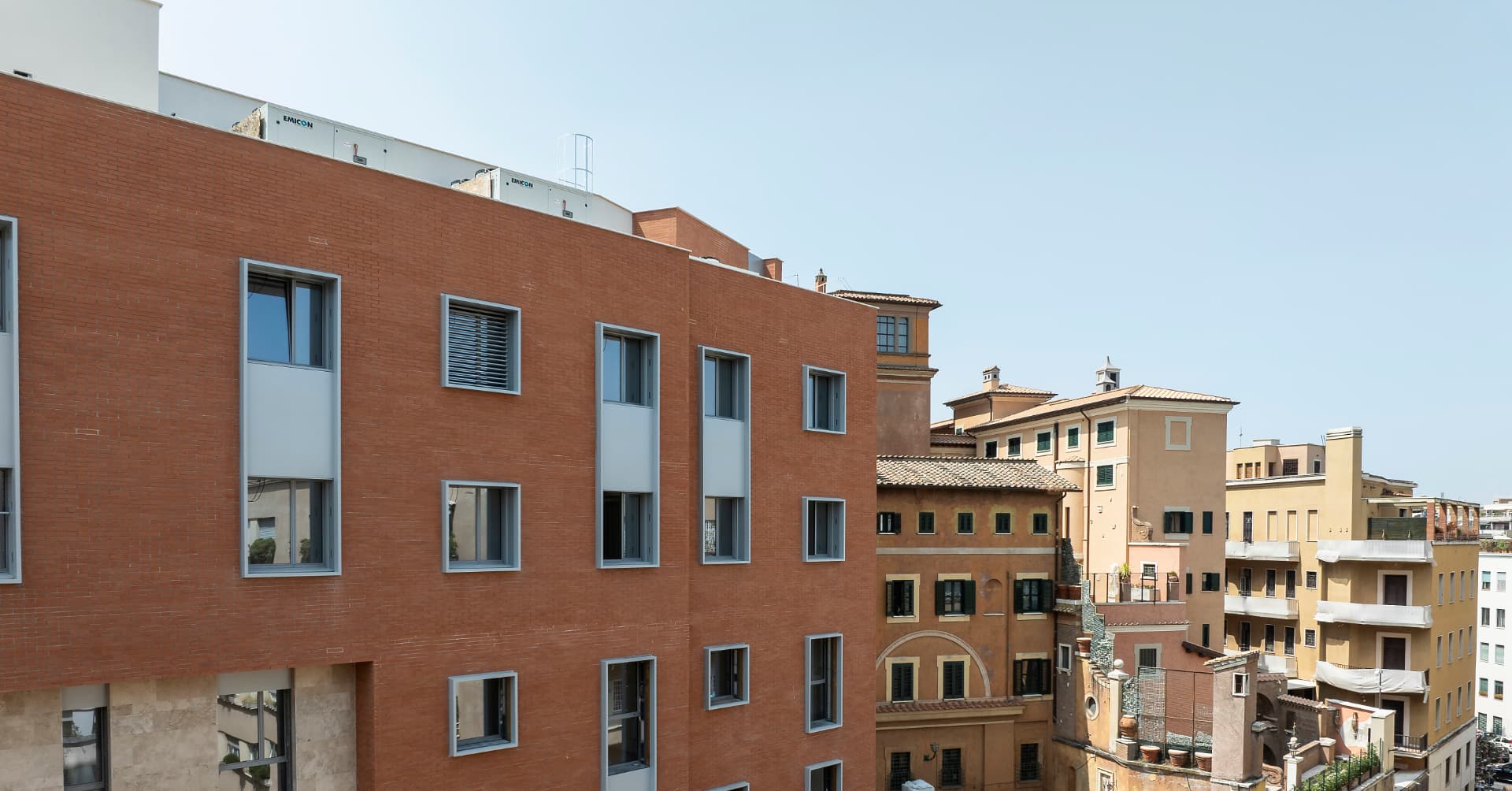 Angolatura del prospetto con finestre a nastro e facciata in laterizio