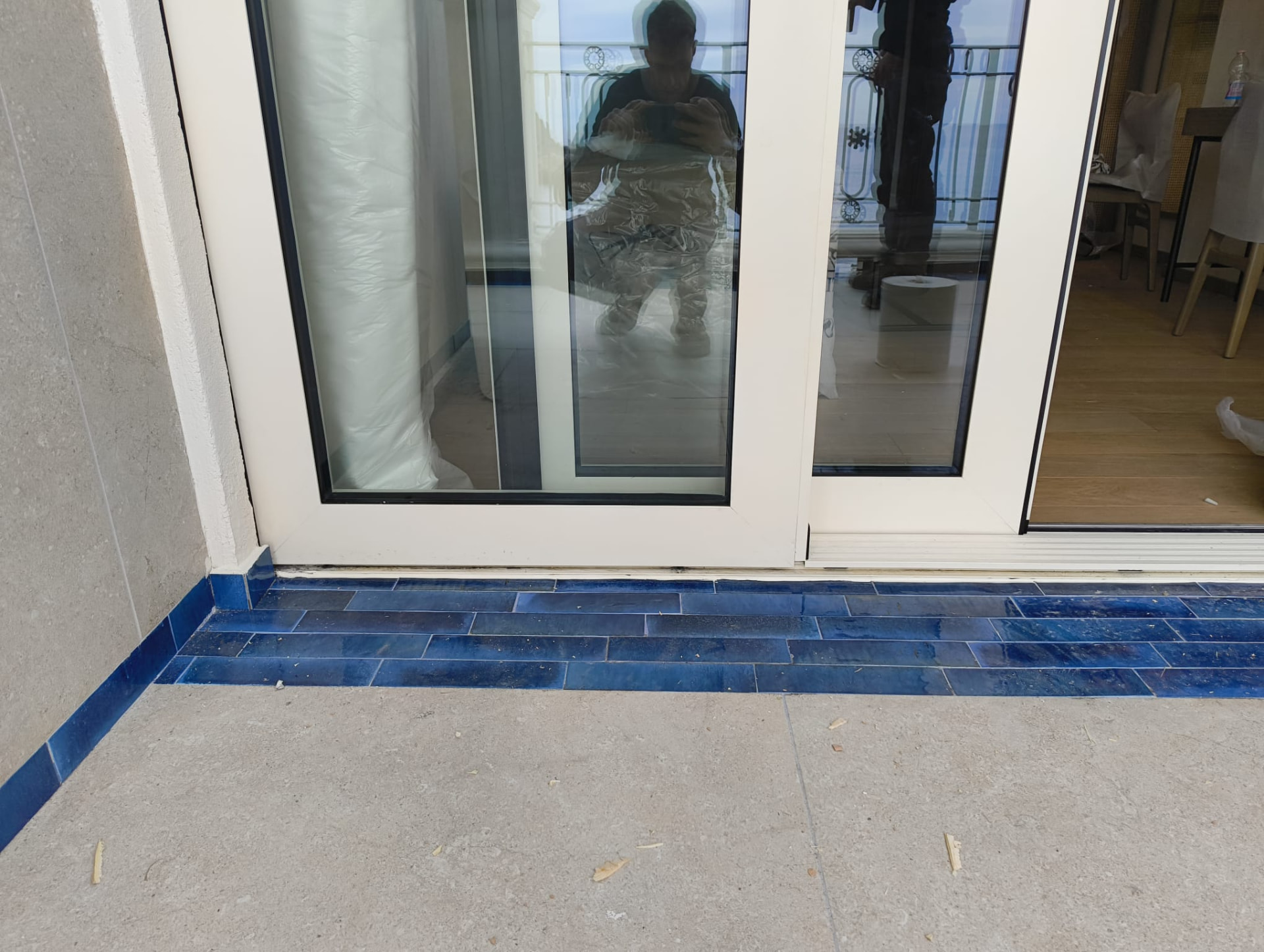Dettaglio della soglia a pavimento dello scorrevole con piastrelle in ceramica blu