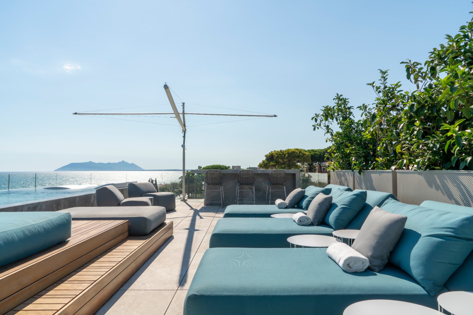 Zona relax esterna con divani azzurri e vista sull'Argentario