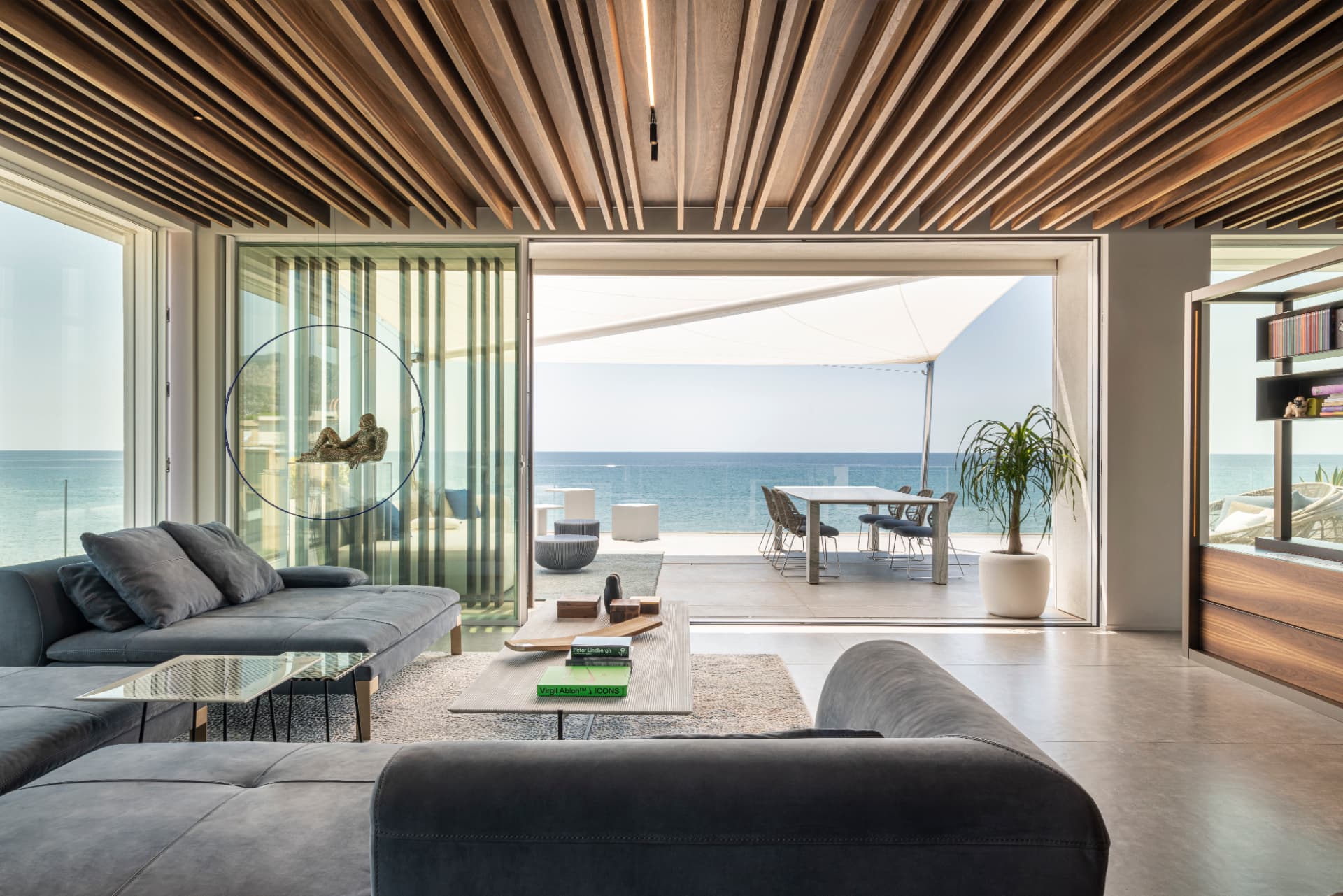 Soggiorno con soffitto in legno e vetrata aperta sulla terrazza vista mare
