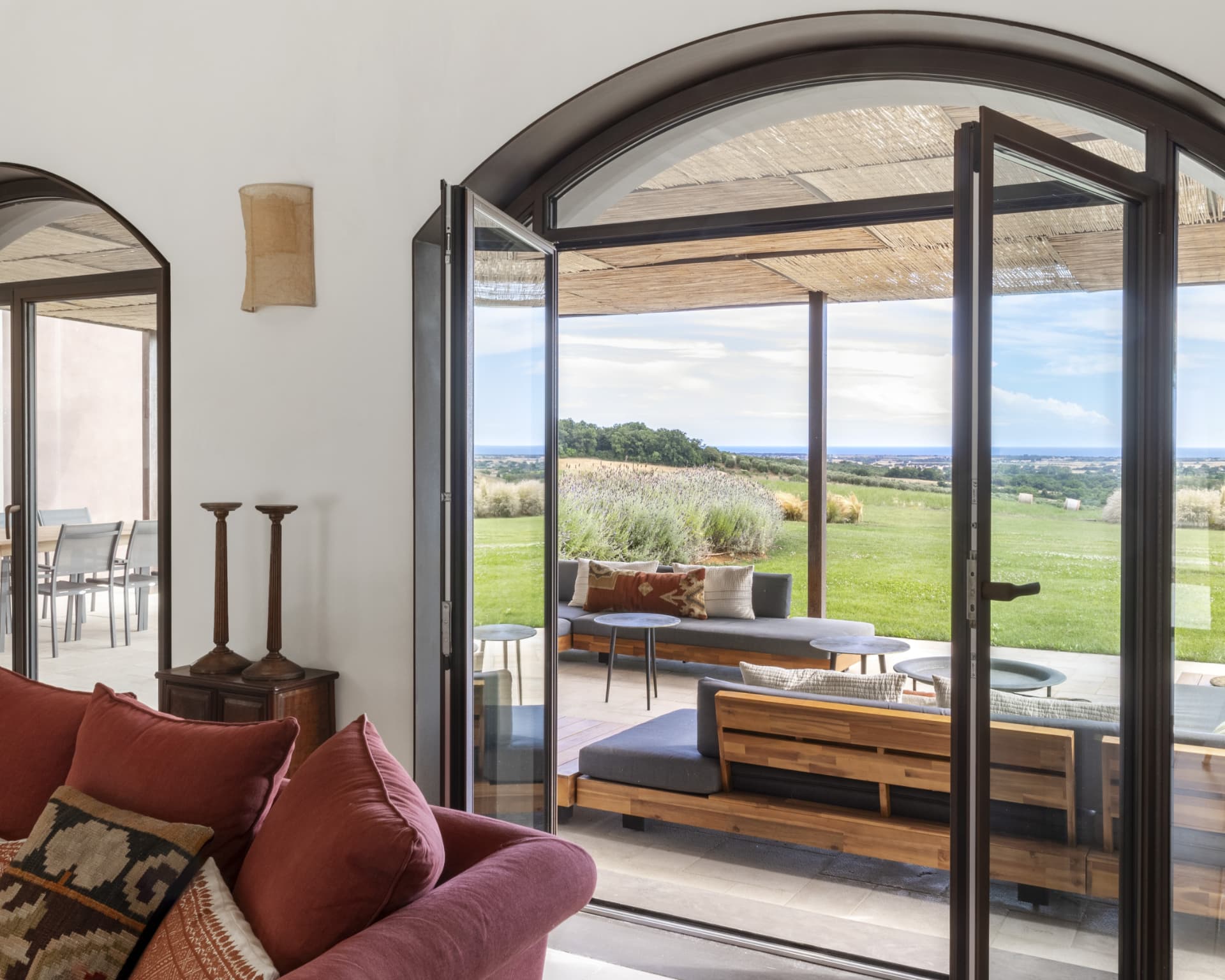 Soggiorno con portafinestra ad arco aperto sul giardino