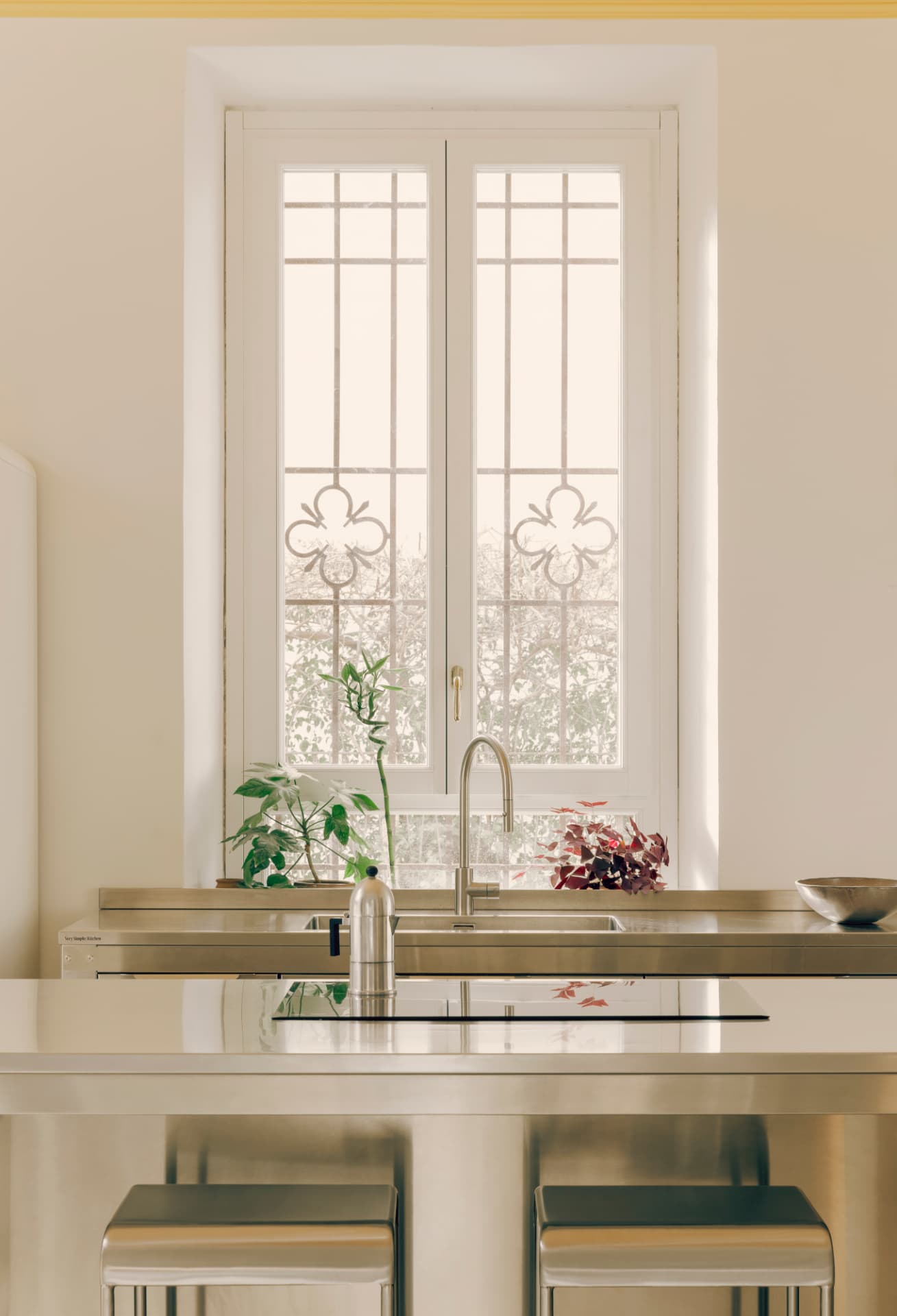 Cucina con finestra in legno e grata in ferro con decoro floreale