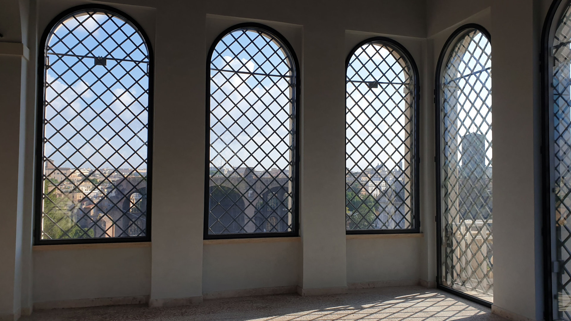 Interno delle Uccelliere con le arcate vetrate e vista su Roma