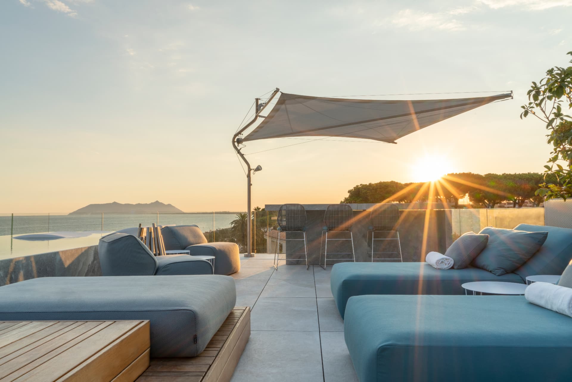 Tramonto sulla terrazza con divani e piscina a sfioro